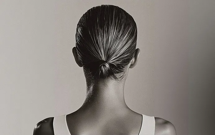 A woman's back of ahead against a grayscale background