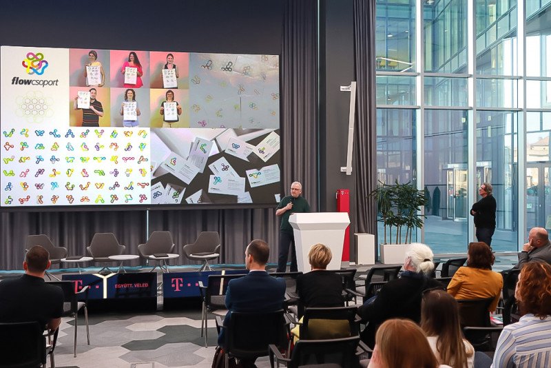 Előadás a Márkaépítés 2022 konferencián, a kivetítőn a Flow Csoport dinamikus arculata