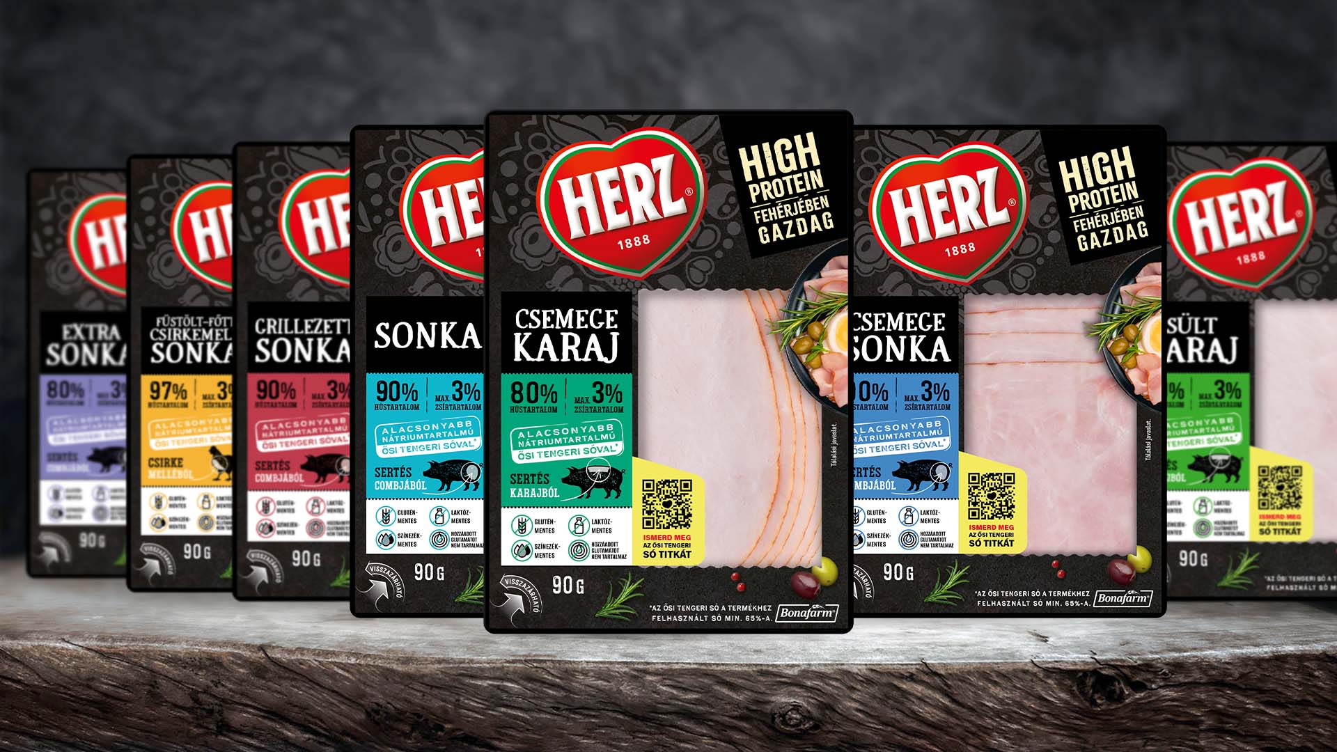 Herz szeletelt sonkák és karajok új, fekete tálcás csomagolásai sorban – csomagolástervezés