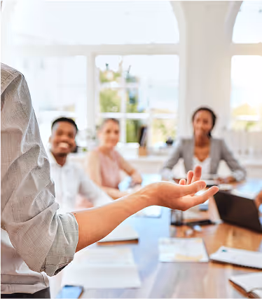 A man in a white shirt is talking to a group of people.