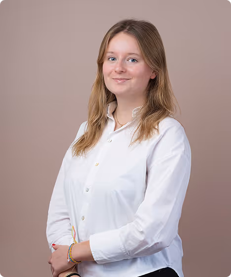 A woman wearing a red sweater and a necklace.