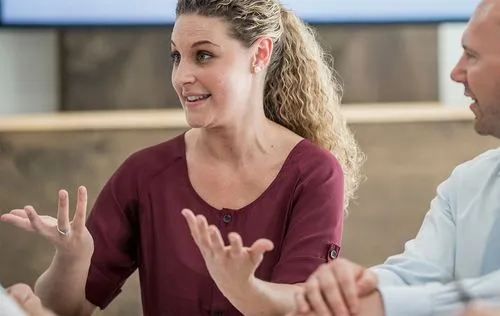 Woman participating in focus group, talking and motioning with her hands.