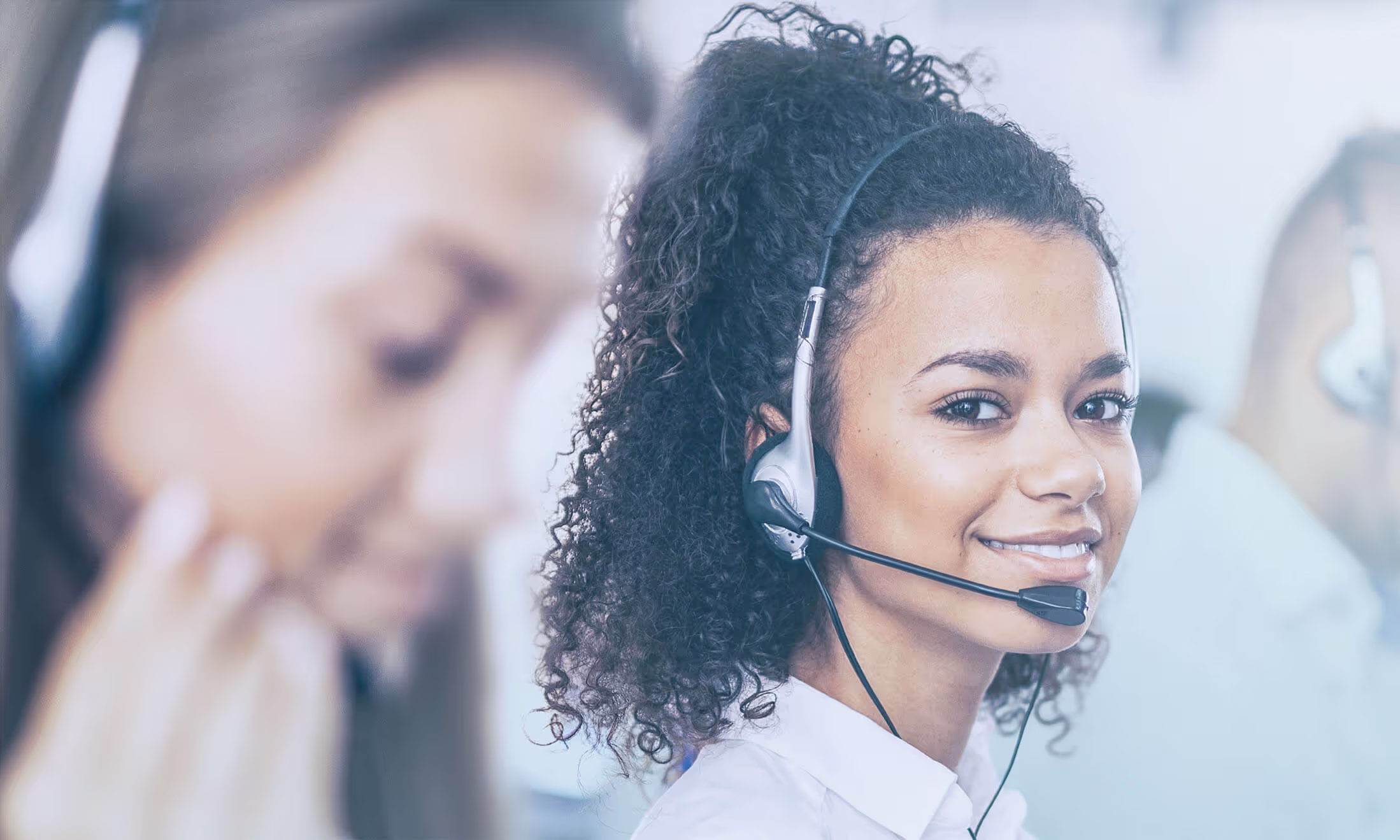 Female customer care specialist smiling with headset.
