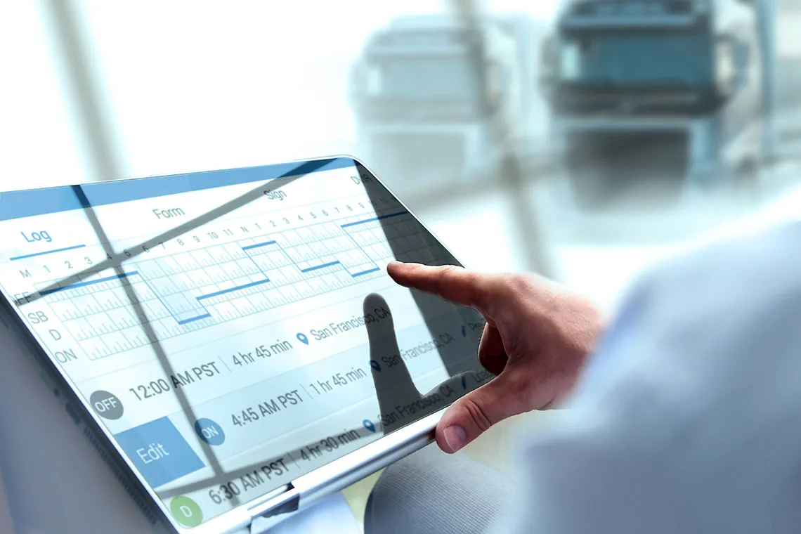Household Goods manager sending invoice tp relocation management company using a tablet (truck in background).
