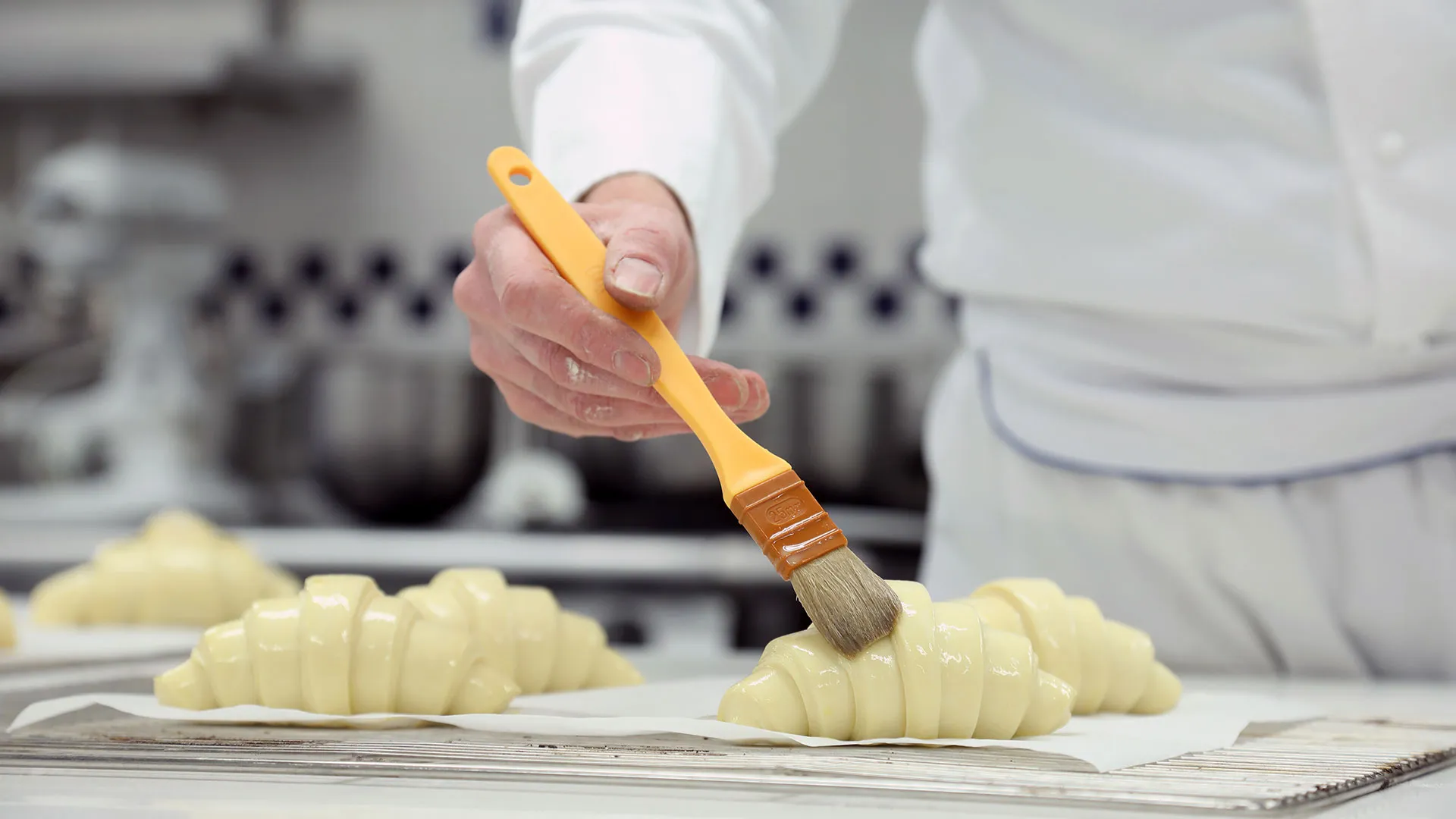 Person buttering croissant