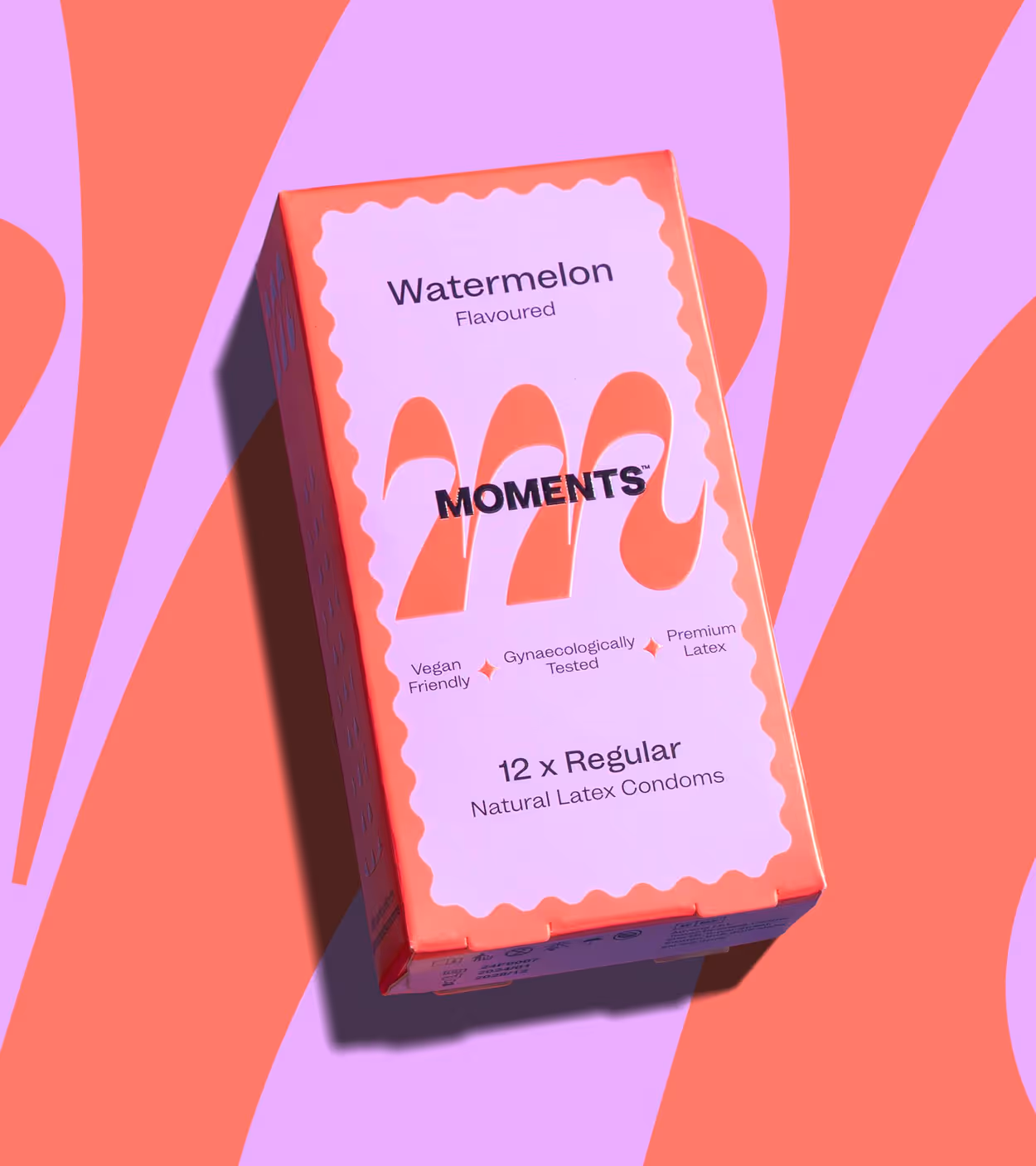 Box of watermelon-flavored natural latex condoms labeled Moments, vegan friendly, gynaecologically tested, containing 12 regular condoms.