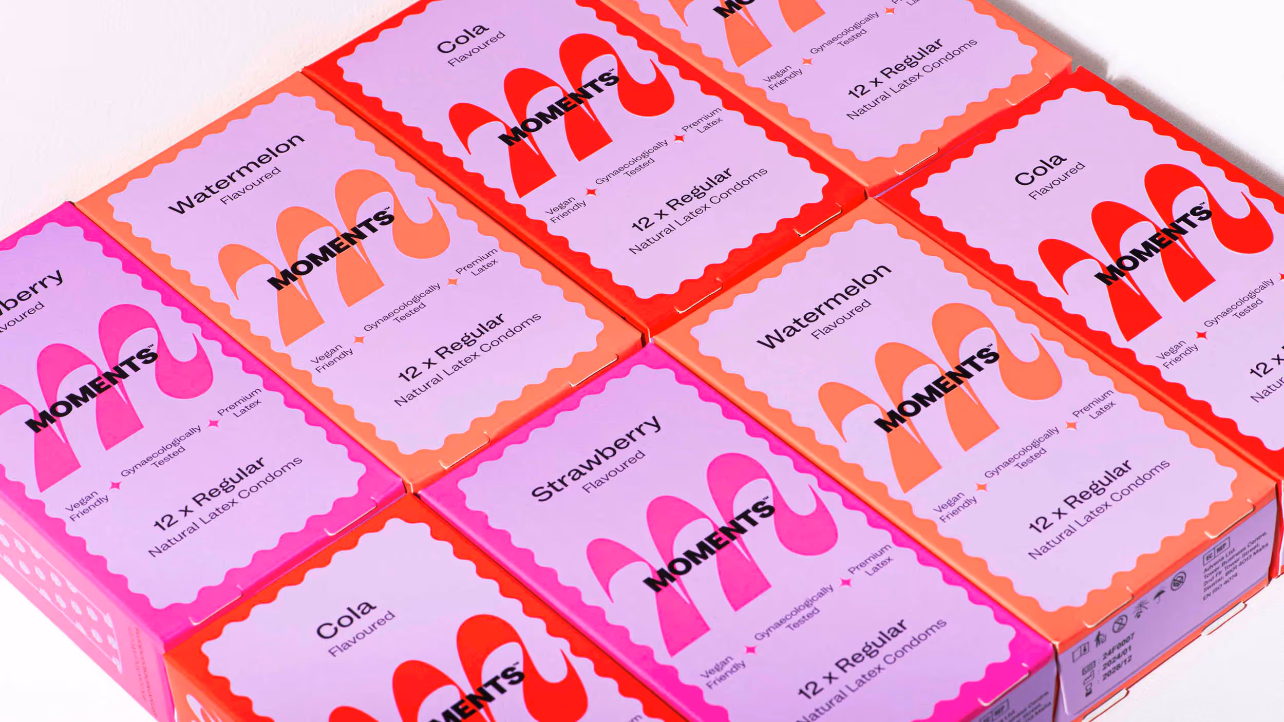 Boxes of Moments flavoured natural latex condoms in strawberry, watermelon, and cola varieties.