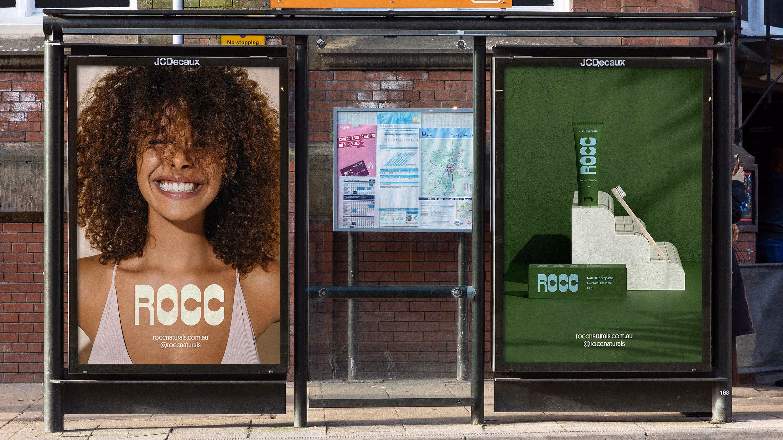 Bus stop posters: left shows a smiling woman with curly hair and ROCC branding; right displays ROCC natural toothpaste packaging and a toothbrush on a green background.