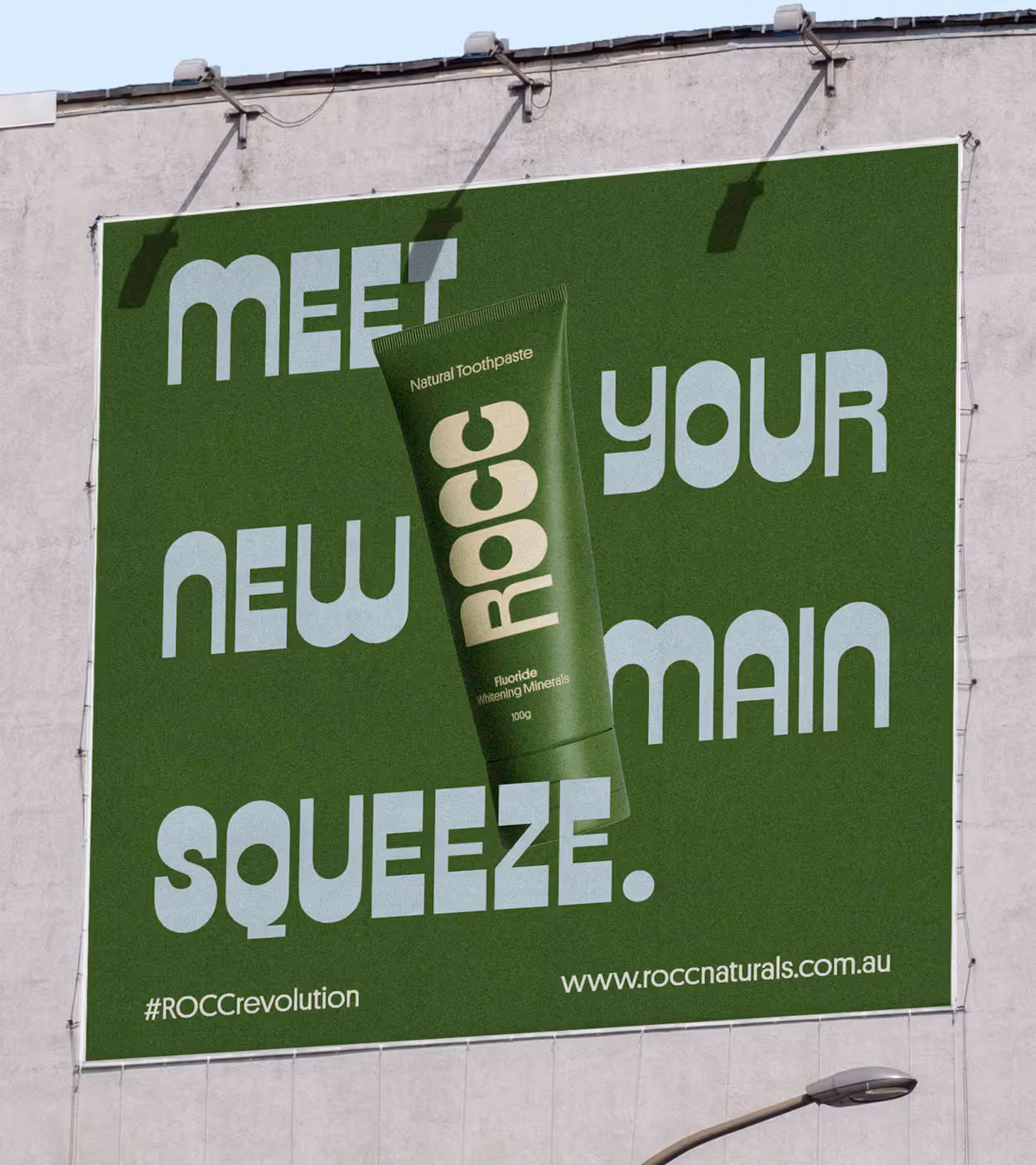 Outdoor billboard advertising green ROCc natural toothpaste with text 'Meet your new main squeeze.' and website roccnaturals.com.au.