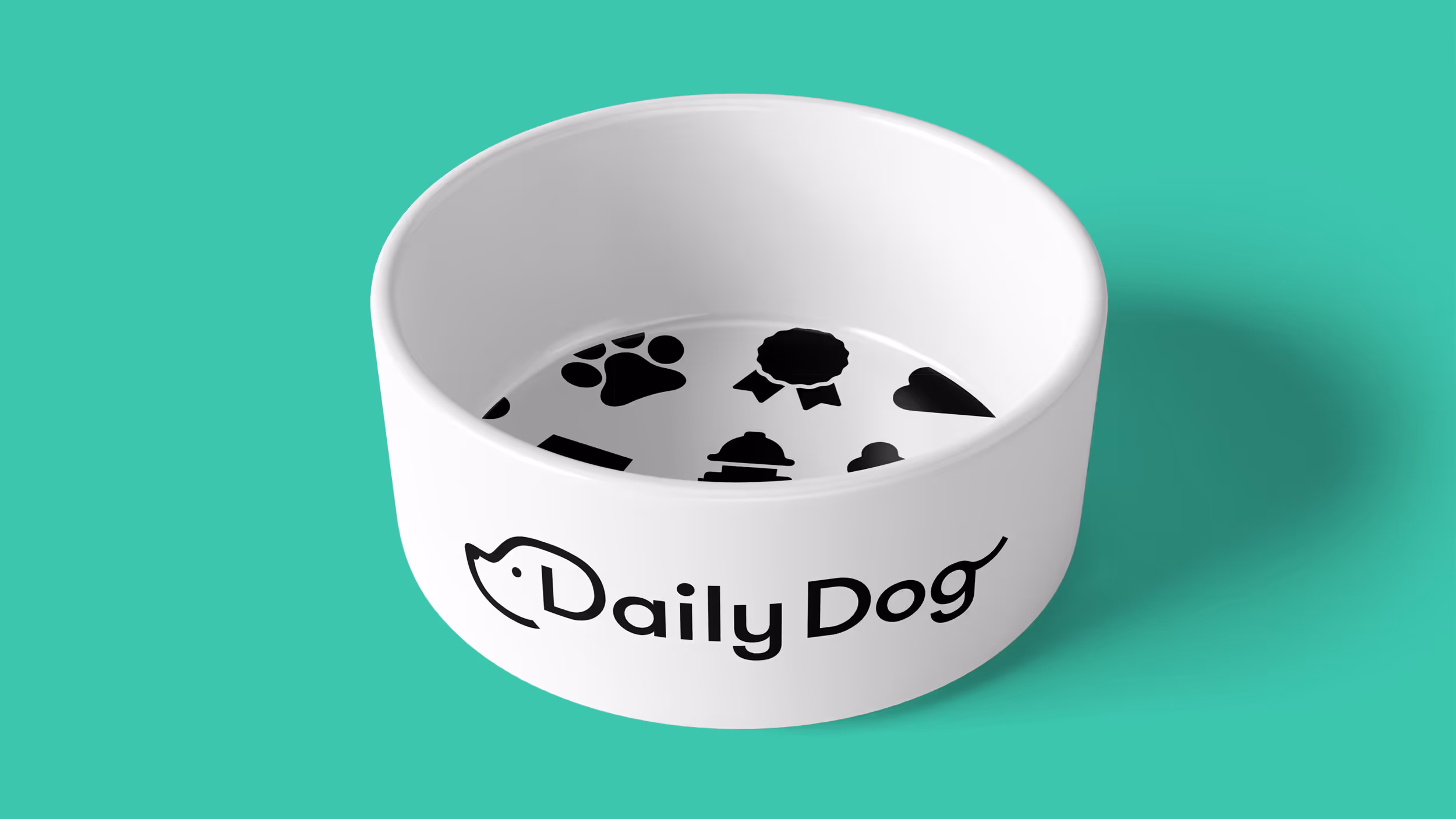 White dog bowl with black Daily Dog logo and black paw, ribbon, and heart icons inside, on a turquoise background.