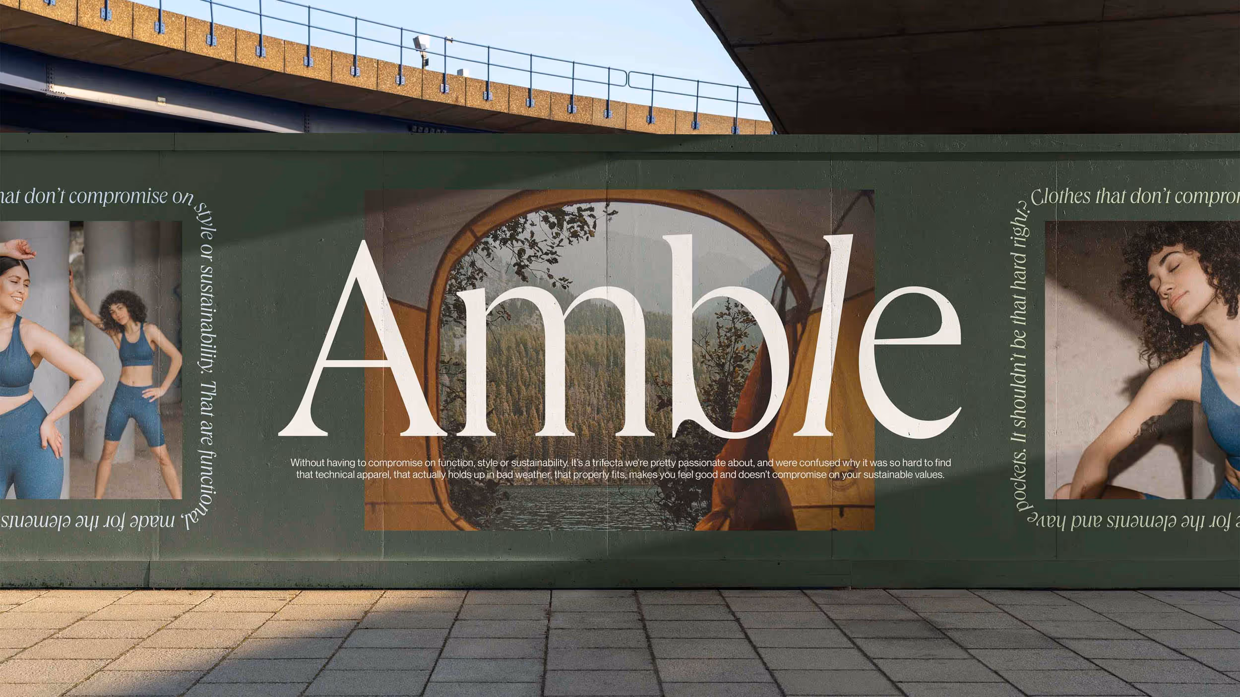 Outdoor green wall advertisement for Amble featuring women in blue activewear and a scenic tent view over a forest lake.
