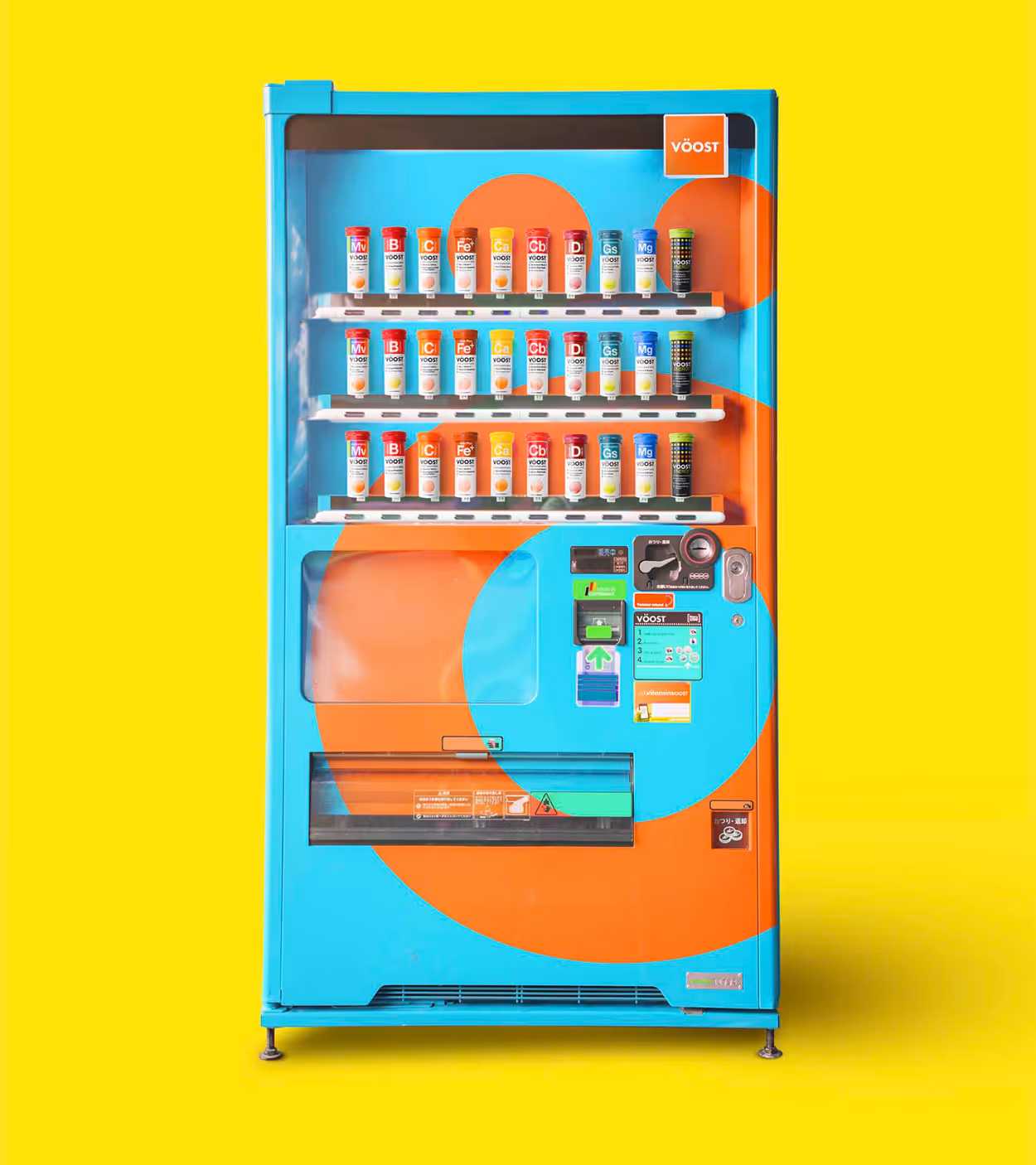 Blue and orange vending machine against a yellow background, stocked with three rows of colorful vitamin supplement bottles.