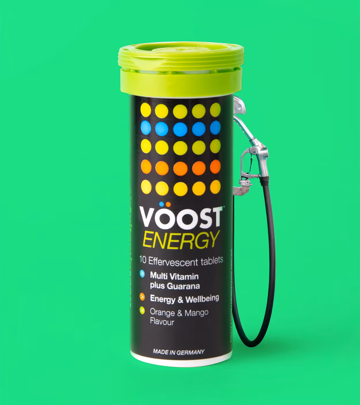 Black container of Vöost Energy effervescent tablets with colorful dots and a green lid, connected to a fuel pump nozzle on a green background.