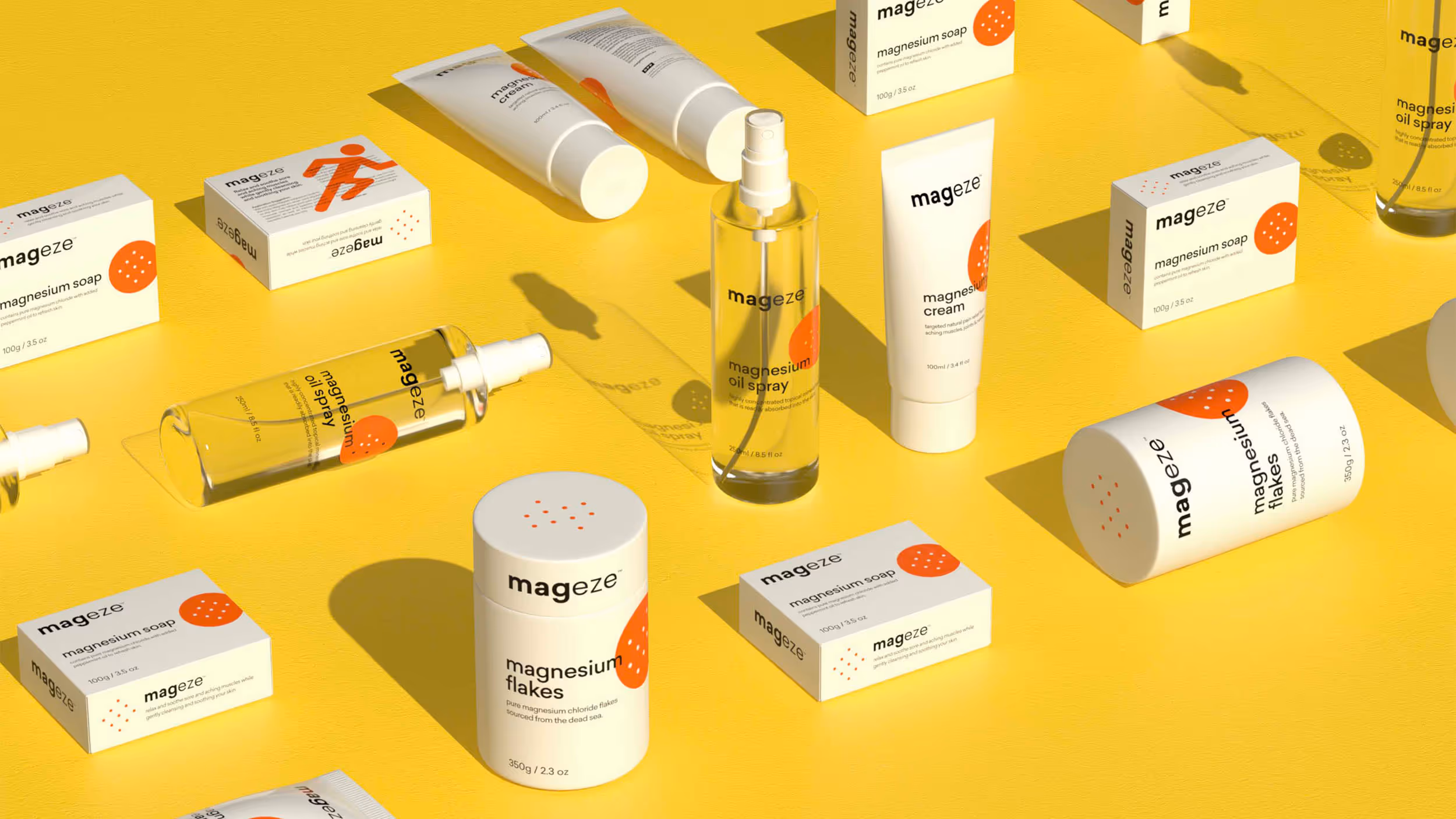Various Mageze magnesium skincare products including soap boxes, cream tubes, oil spray bottles, and magnesium flakes containers arranged on a yellow surface.