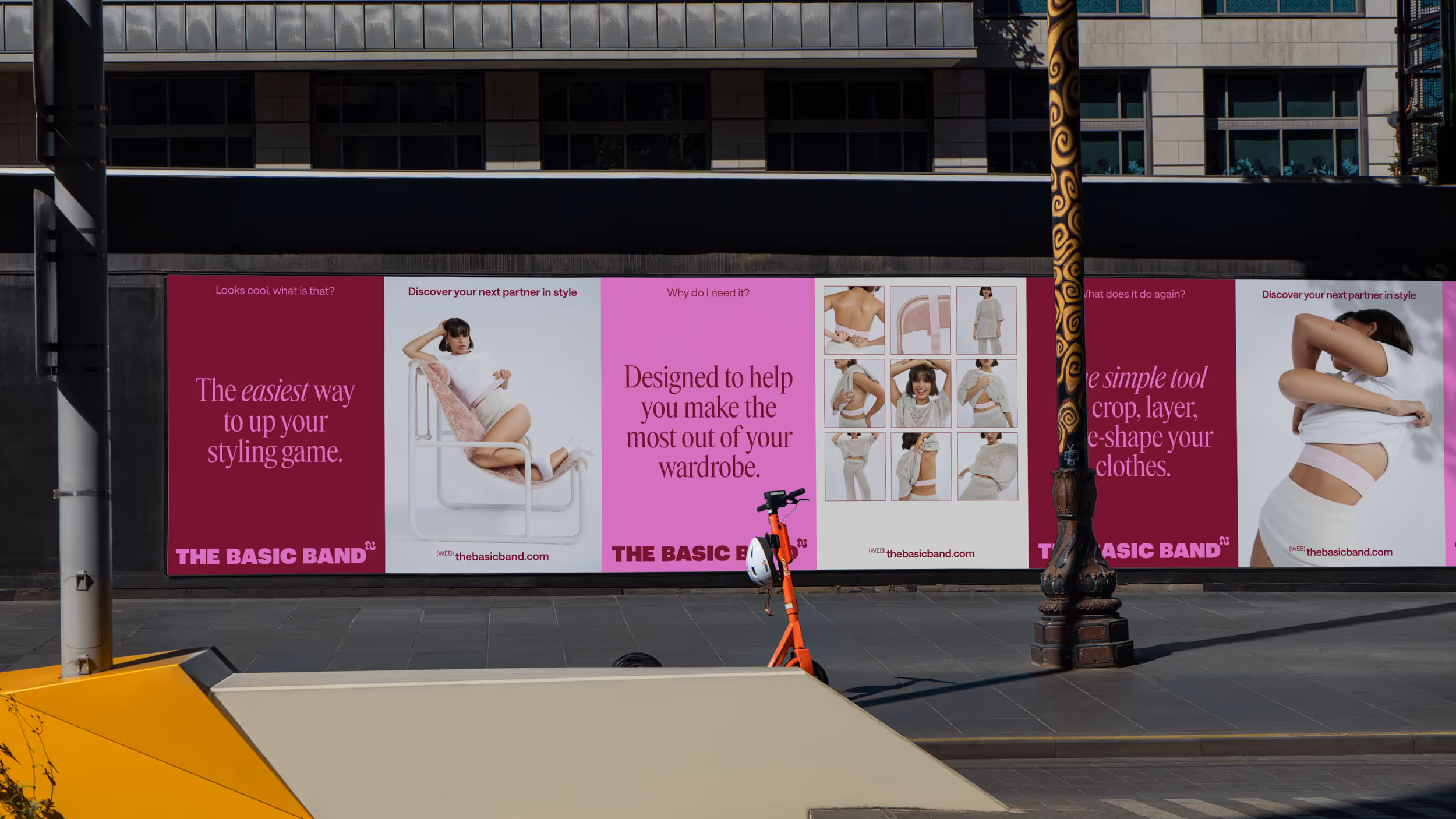 Street billboard advertising The Basic Band with images demonstrating a woman using a styling band under her clothing and text promoting it as an easy styling tool to enhance your wardrobe.