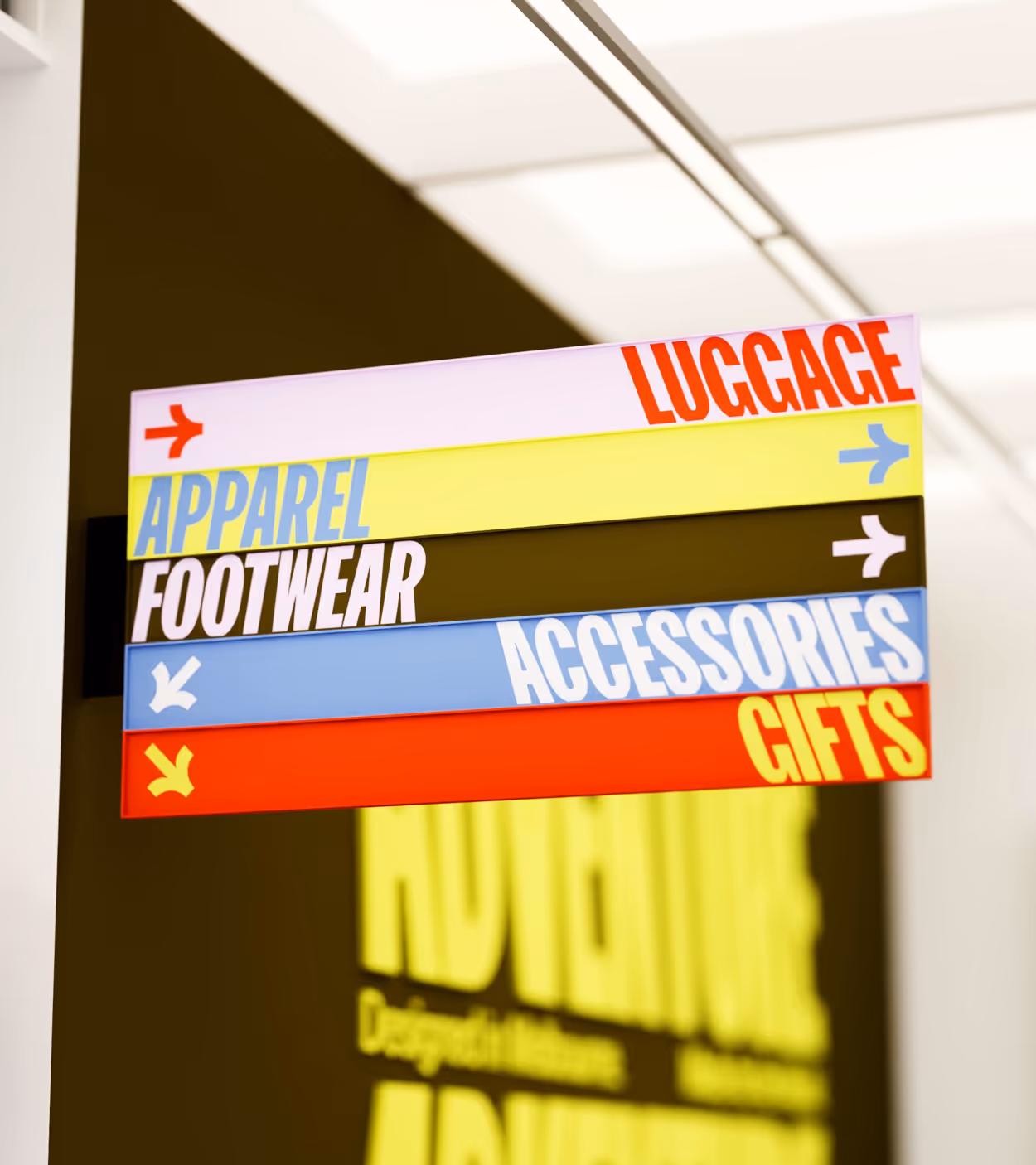 Colorful directional store sign with categories: Luggage, Apparel, Footwear, Accessories, and Gifts.