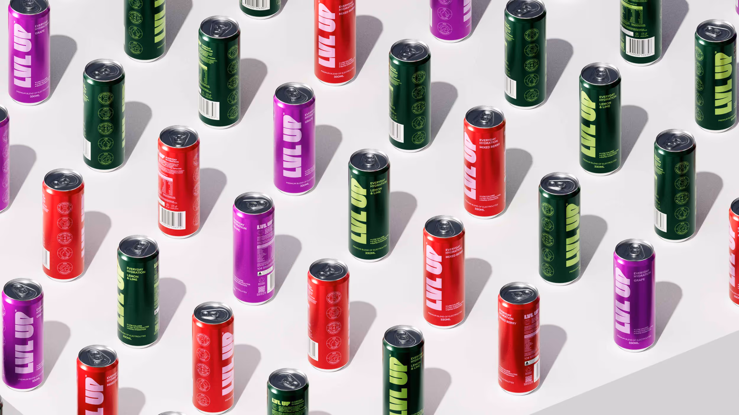 Scattered cans of LVL UP hydration drinks in red, purple, and green on a white surface casting soft shadows.