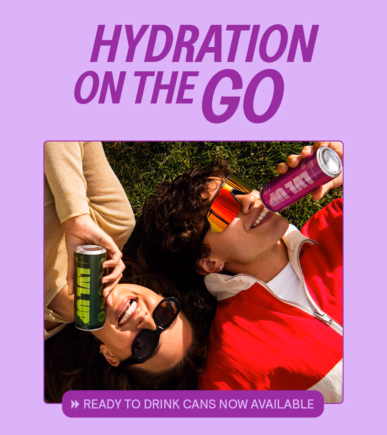 Two people lying on grass wearing sunglasses and drinking ready-to-drink cans labeled LVL UP.
