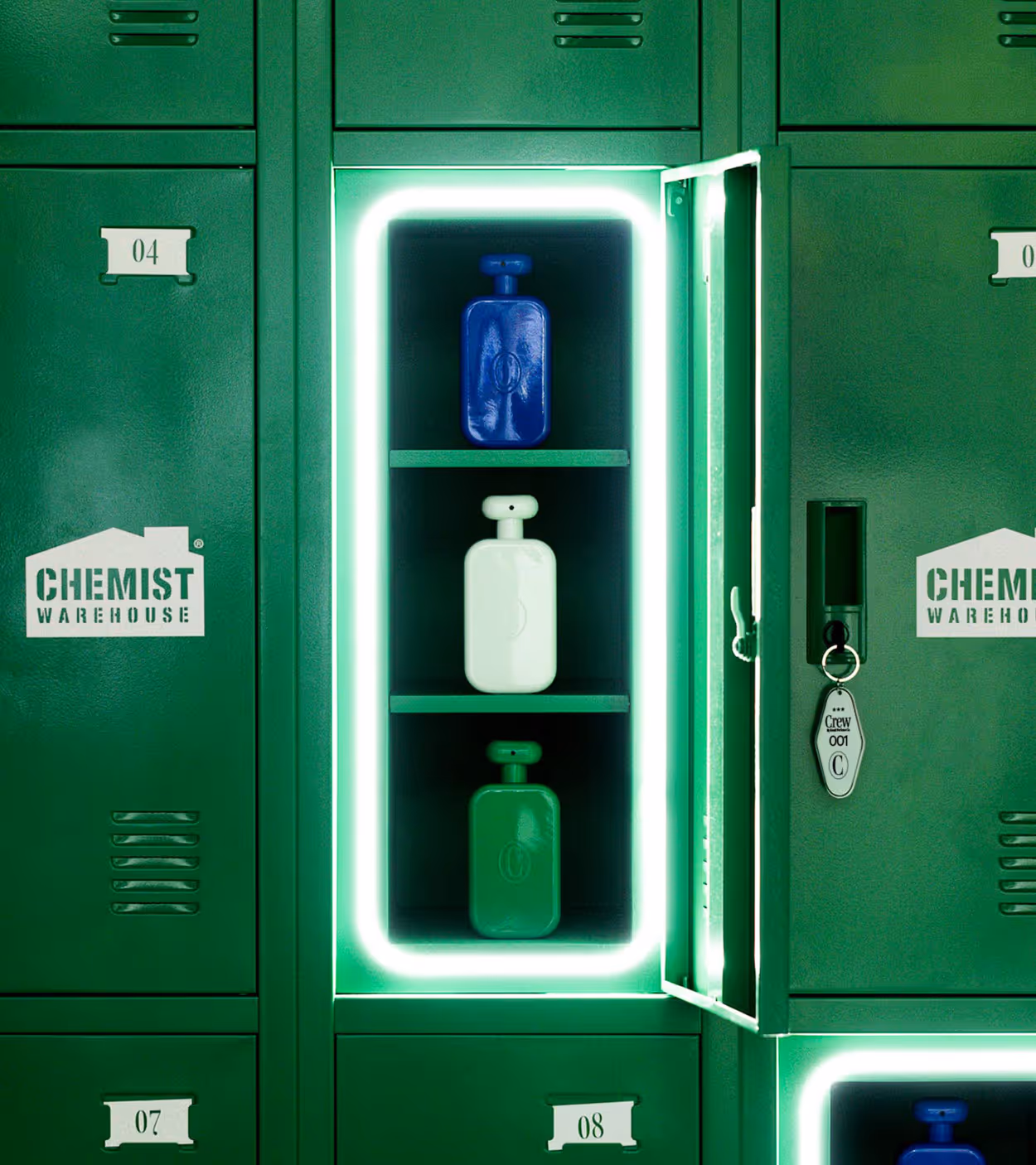Green metal locker with an open door revealing blue, white, and green bottles illuminated by a neon green light frame inside.