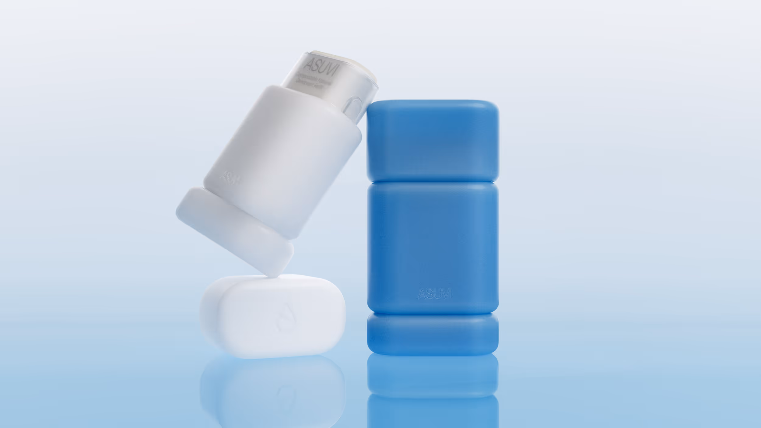Two modern, minimalist containers, one standing vertically in blue and the other in white leaning against it with a translucent lid.