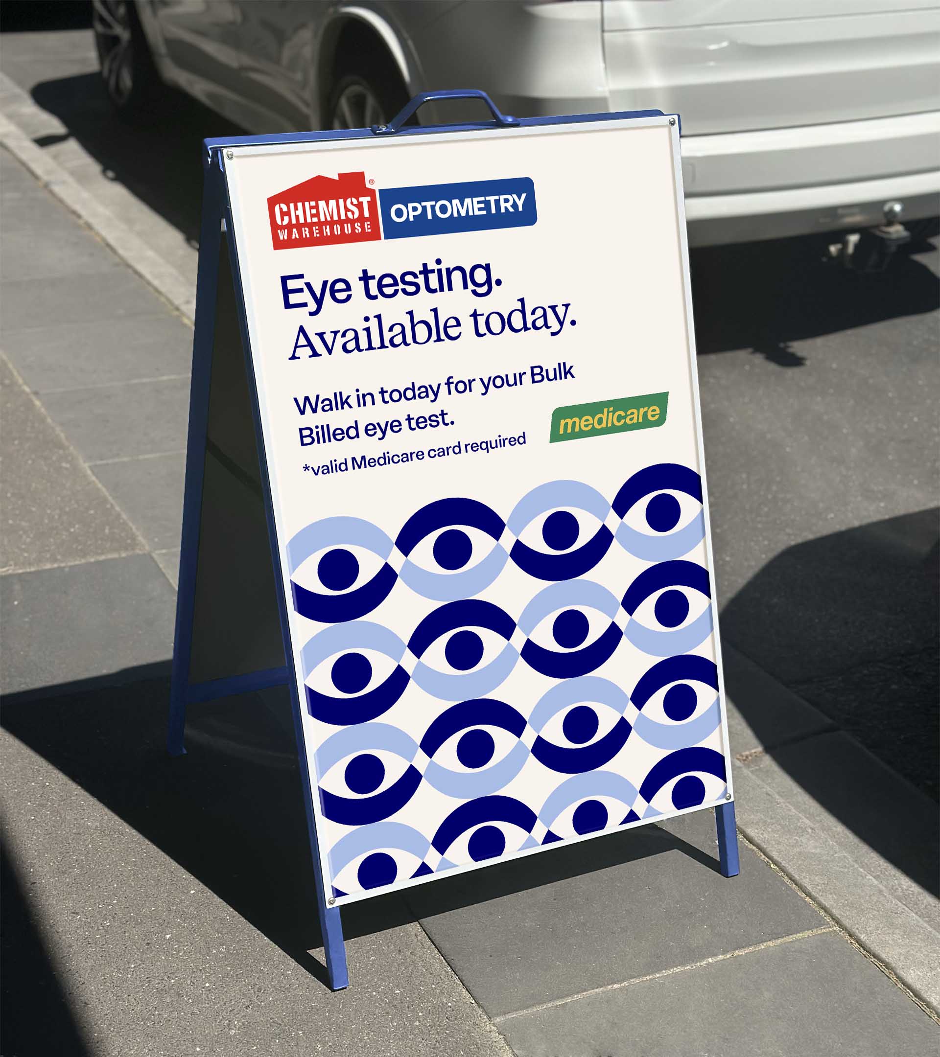 Sidewalk sign advertising Chemist Warehouse Optometry offering bulk billed eye testing with valid Medicare card required.