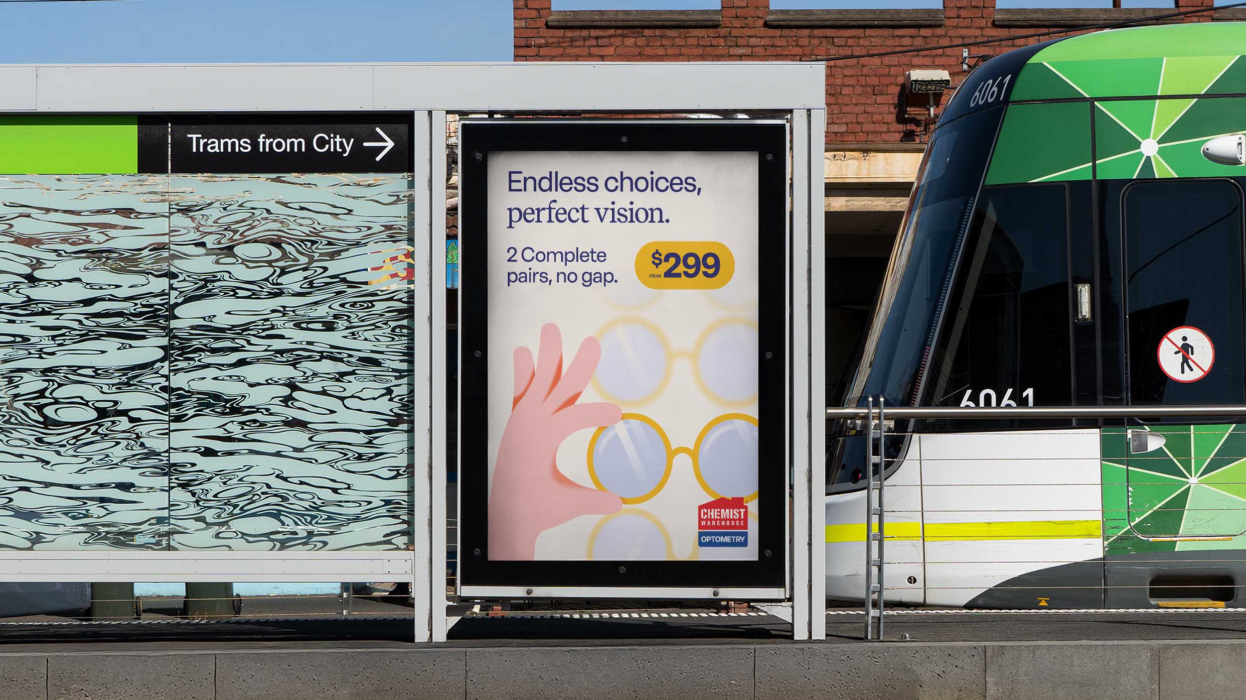 Tram stop with a green tram visible and an advertisement for Chemist Warehouse optometry offering two complete pairs of glasses from $299.