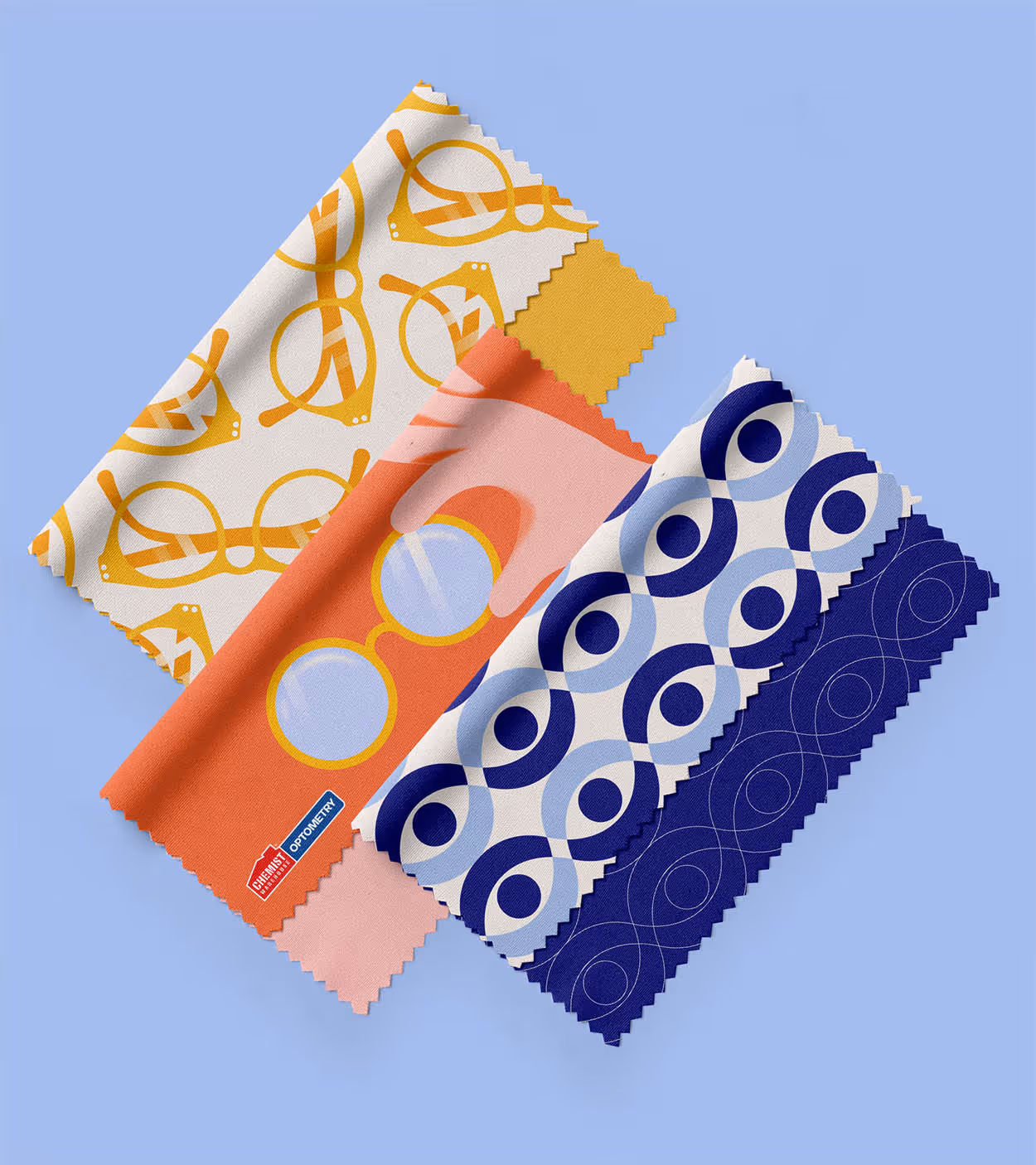 Four colorful patterned cleaning cloths arranged on a blue background, featuring eyeglass and circular designs.