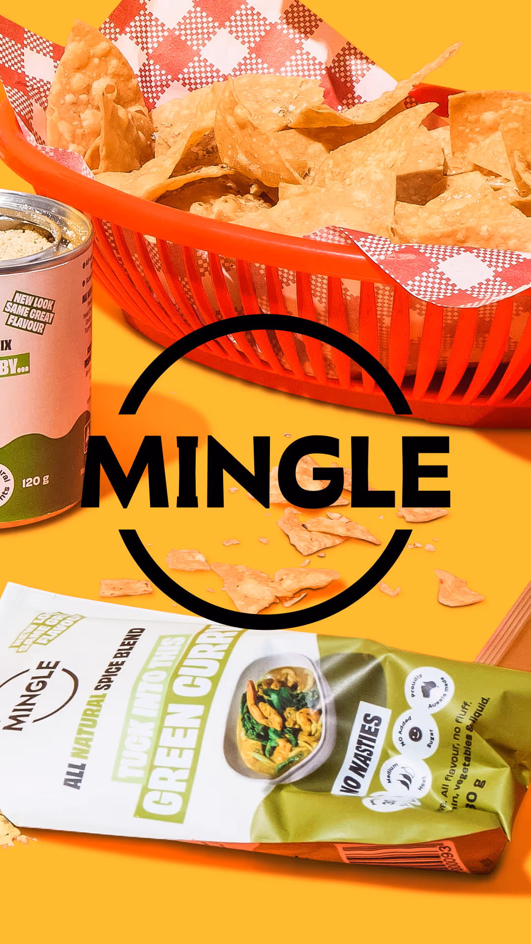 Red basket with tortilla chips, spice mix can, and green curry spice blend packet on yellow background