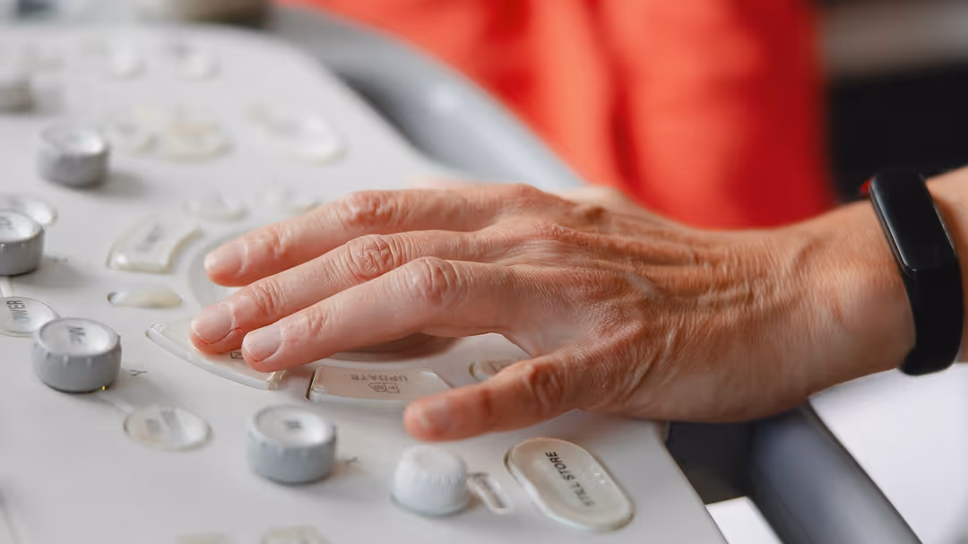 Hand eines Arztes oder Technikers, die ein Ultraschallgerät bedient.