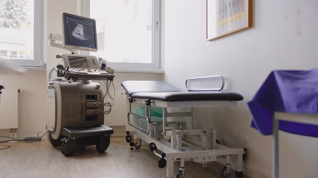 Ultraschallgerät und Untersuchungsliege in einem hellen, modernen Untersuchungsraum.