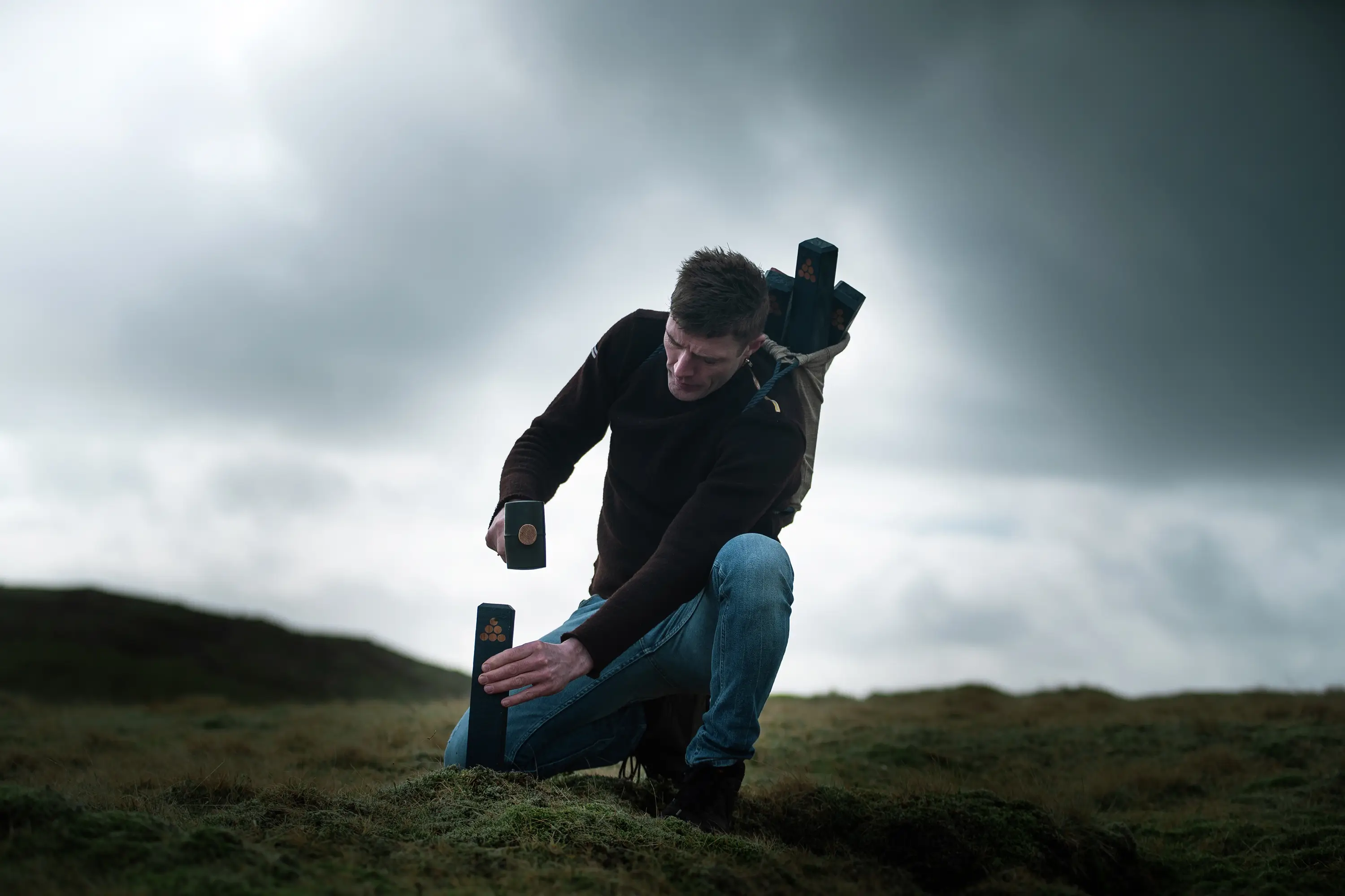 Mynd av manni ið setir pela niður, í haganum