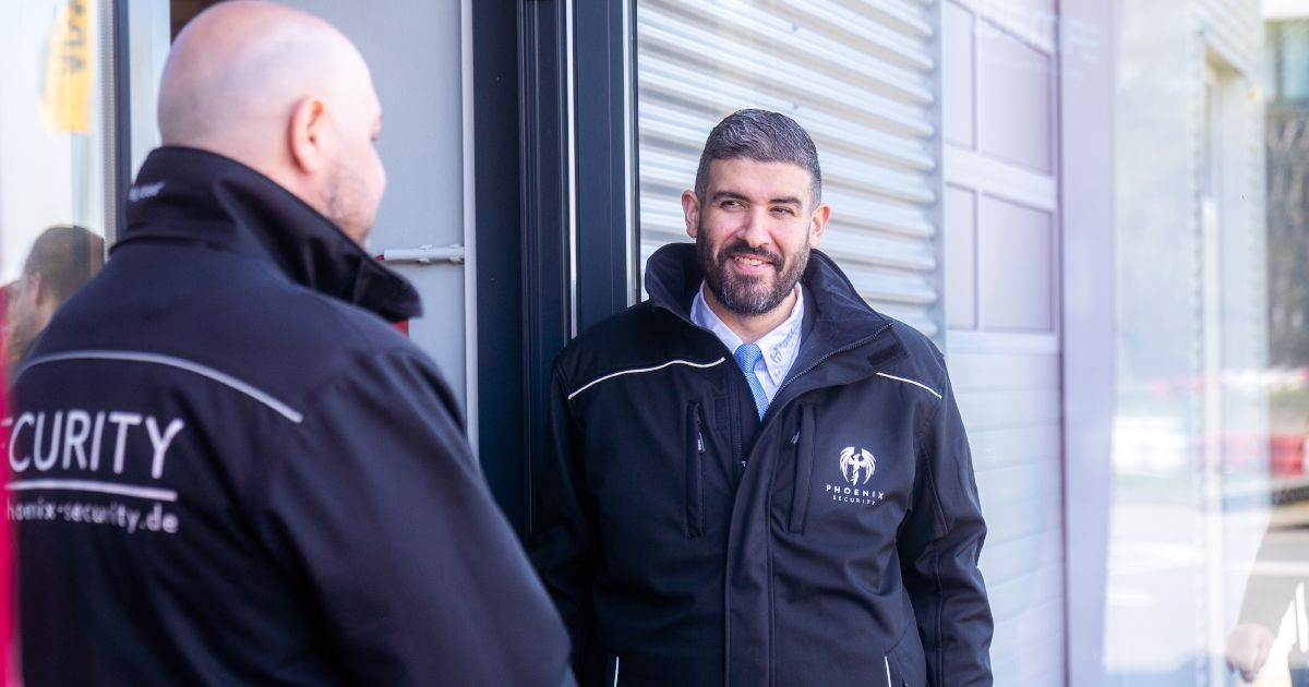 Sicherheitsmitarbeiter von Phoenix Security, bewachen Eingangsbereich, mit Dienstkleidung.