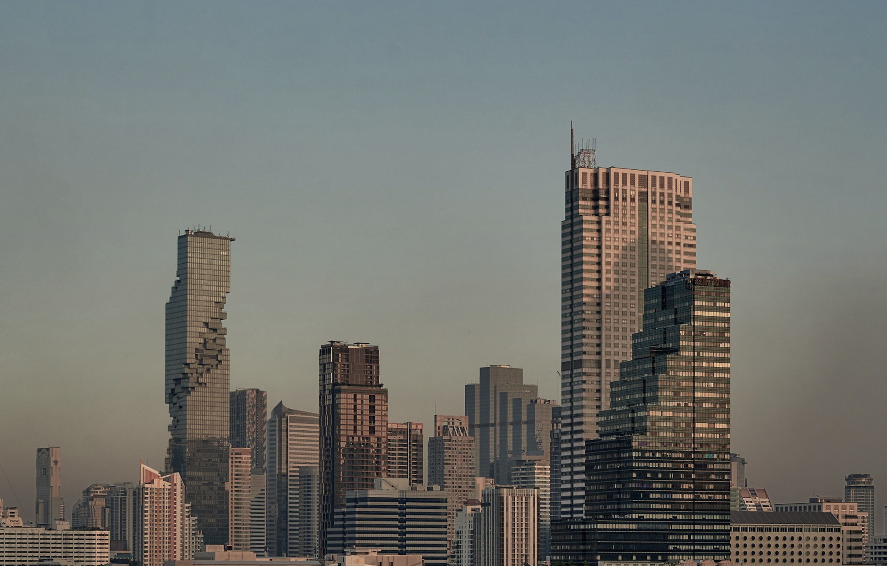 City skyline with modern high-rise buildings under a clear sky at dusk.
