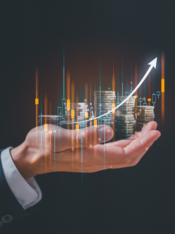 Hand holding stacks of coins with an upward trending financial graph overlay.