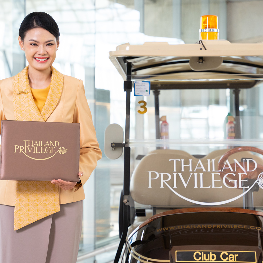 Smiling woman in beige uniform holding a folder labeled 'Thailand Privilege' standing next to a golf cart with 'Thailand Privilege' branding.