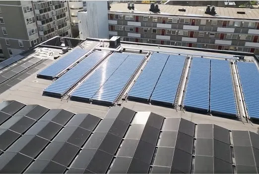 Rooftop with solar panels and buildings in the background under clear daylight.