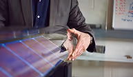 Person explaining solar panel technology with hand gestures over a solar panel.