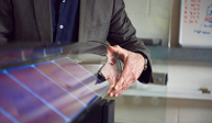 Person explaining solar panel technology with hand gestures over a solar panel.