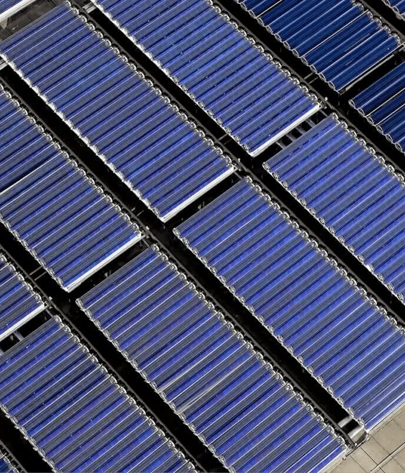 Aerial view of multiple rows of blue solar panels arranged in parallel lines.