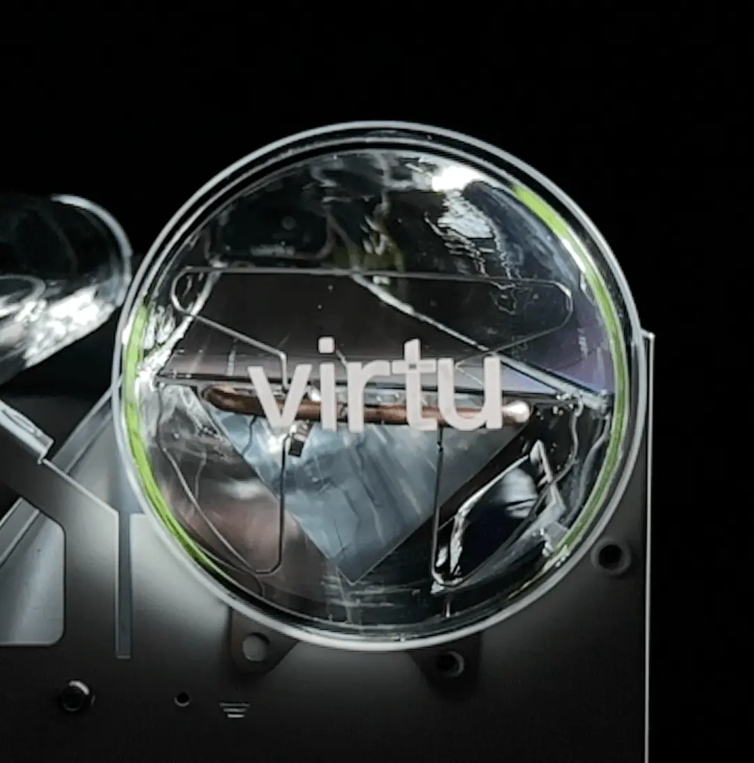 Close-up de um tubo transparente de painel solar óptico com a palavra «virtu» impressa nele, contra um fundo preto.