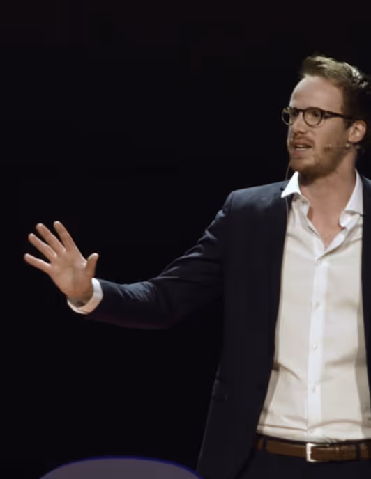 Alex Partridge on stage at a speaking event