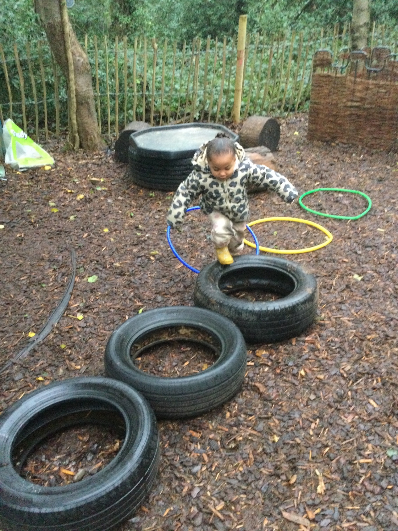 Children enjoying tyre play outdoors at Woodlands Preschool Hemel