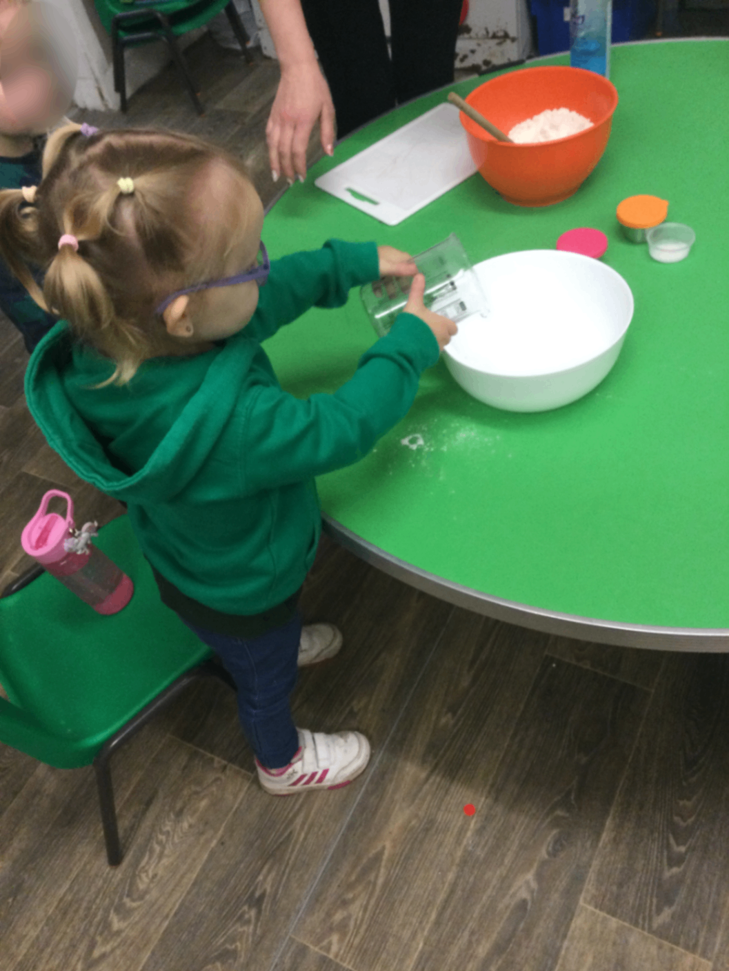A child pouring liquid during indoor sensory play – practising control and coordination