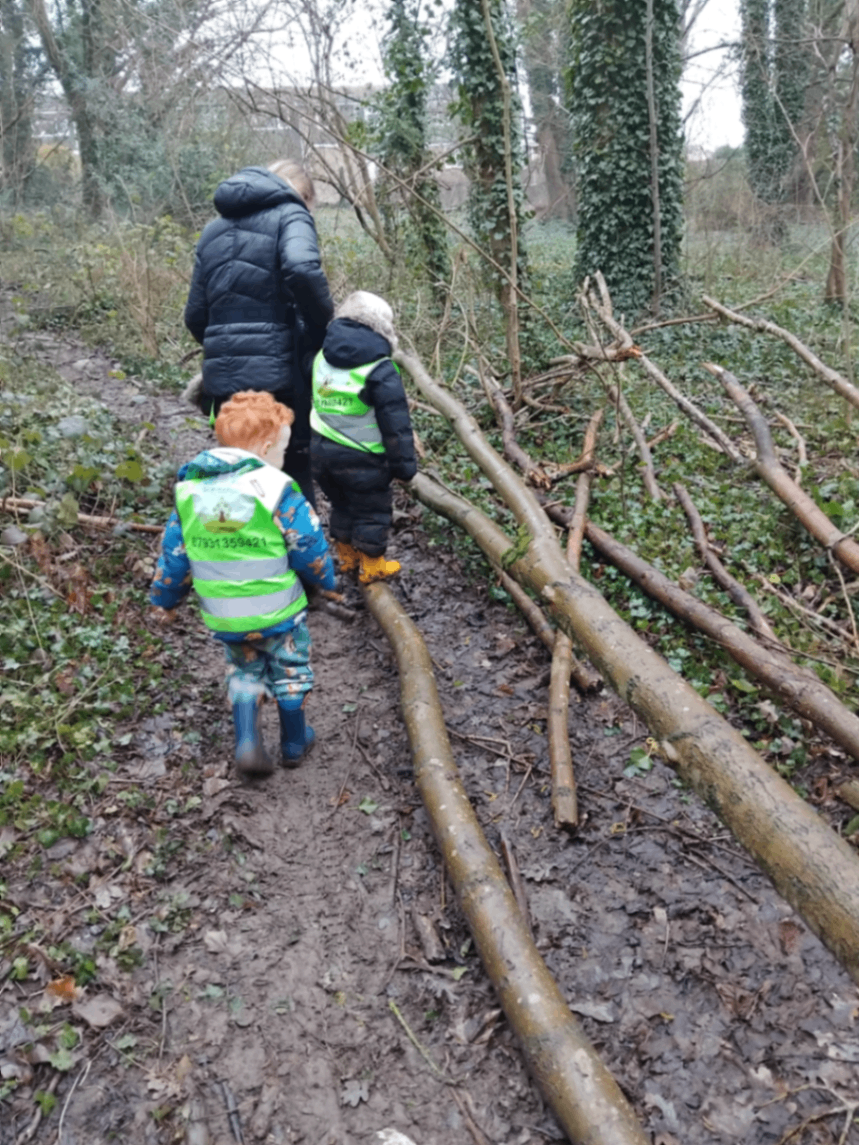 Children exploring a woodland path together in our forest-school-inspired setting