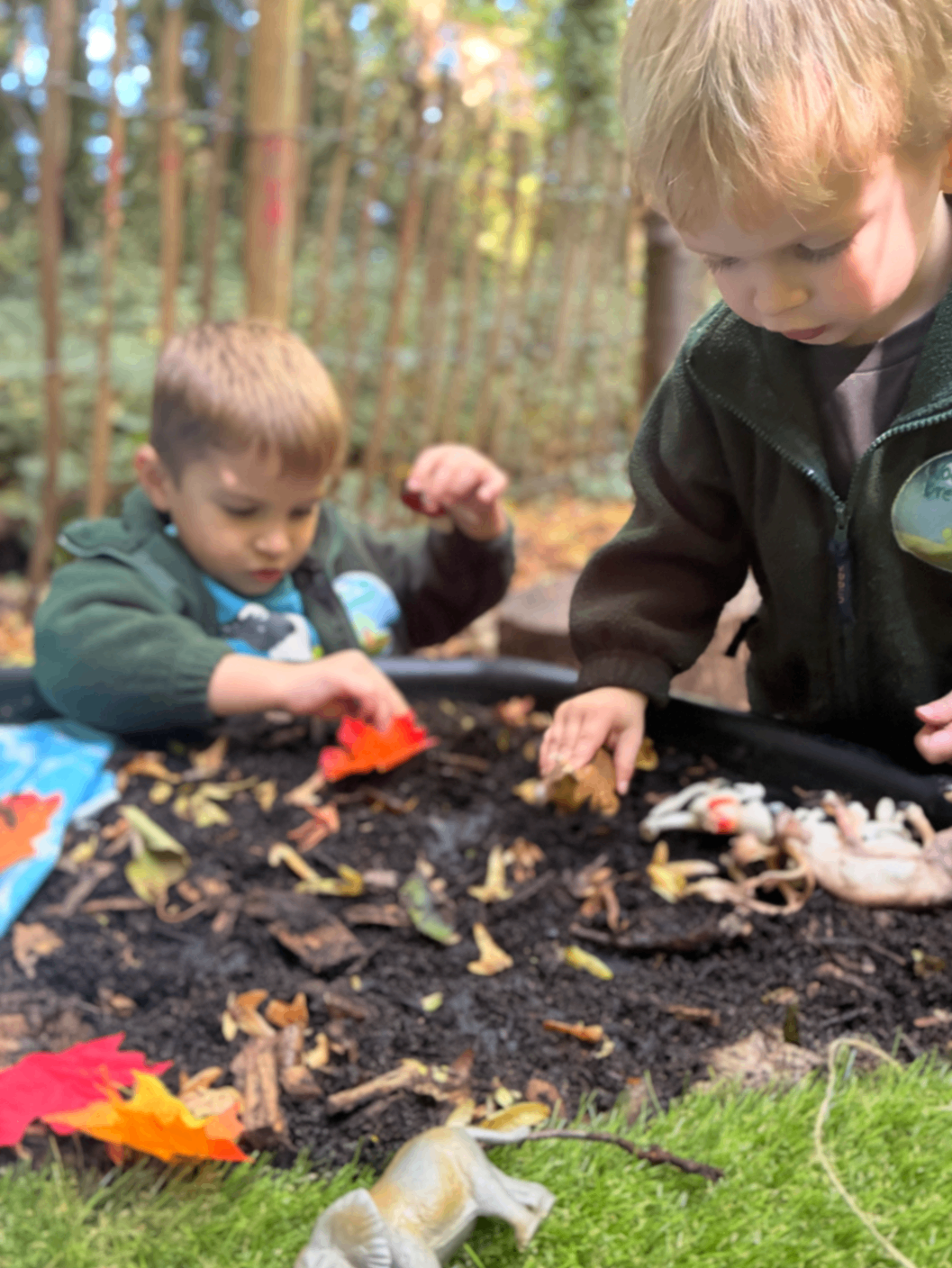 Two preschool children in outdoor forest school clothing