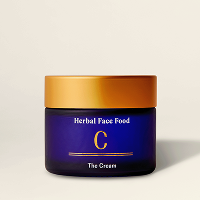 Blue jar of herbal face cream with a gold lid labeled 'Herbal Face Food C The Cream'.