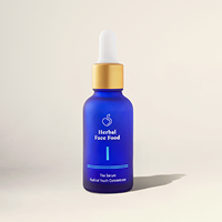 Blue dropper bottle labeled 'Herbal Face Food' with a gold cap casting a shadow on a beige surface.