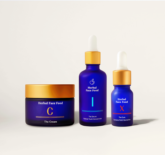 Blue jar of Herbal Face Food C cream with a gold lid on a beige background.