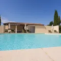 Outdoor pool surrounded by walls and buildings with the blue sky in the background.