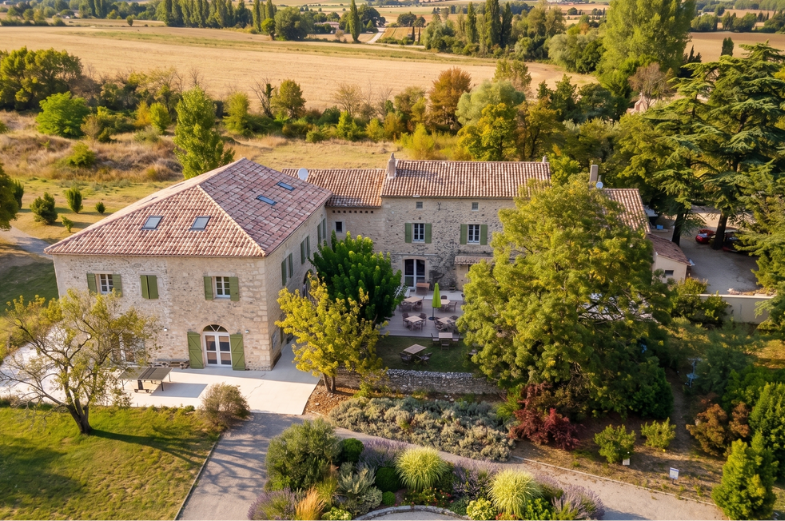 Extérieur du Domaine de la Vivande à La Marsanne, mas provençal en pierre, fontaine octogonale centrale, bassin entouré de lavande et de pots en terre cuite